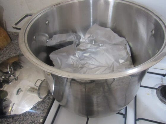 Aluminium foil covering sand in a pot placed on a stove